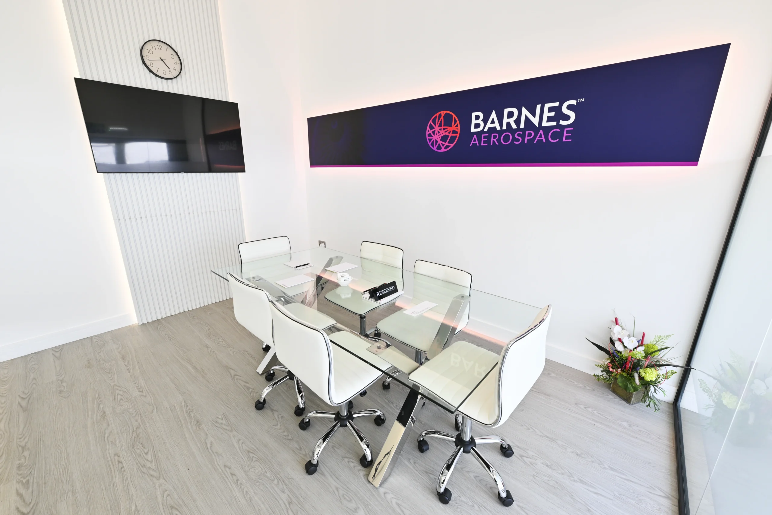 Barnes Aerospace exhibition stand meeting room with branded wall graphics at Farnborough International Airshow 2026