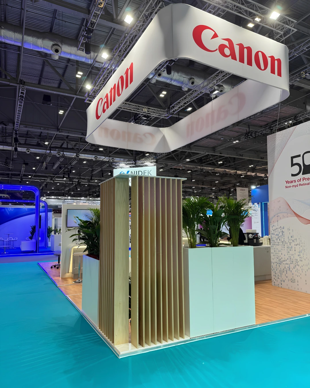 Canon exhibition stand at ESCRS London 2026 with suspended branded canopy, reception area and illuminated displays